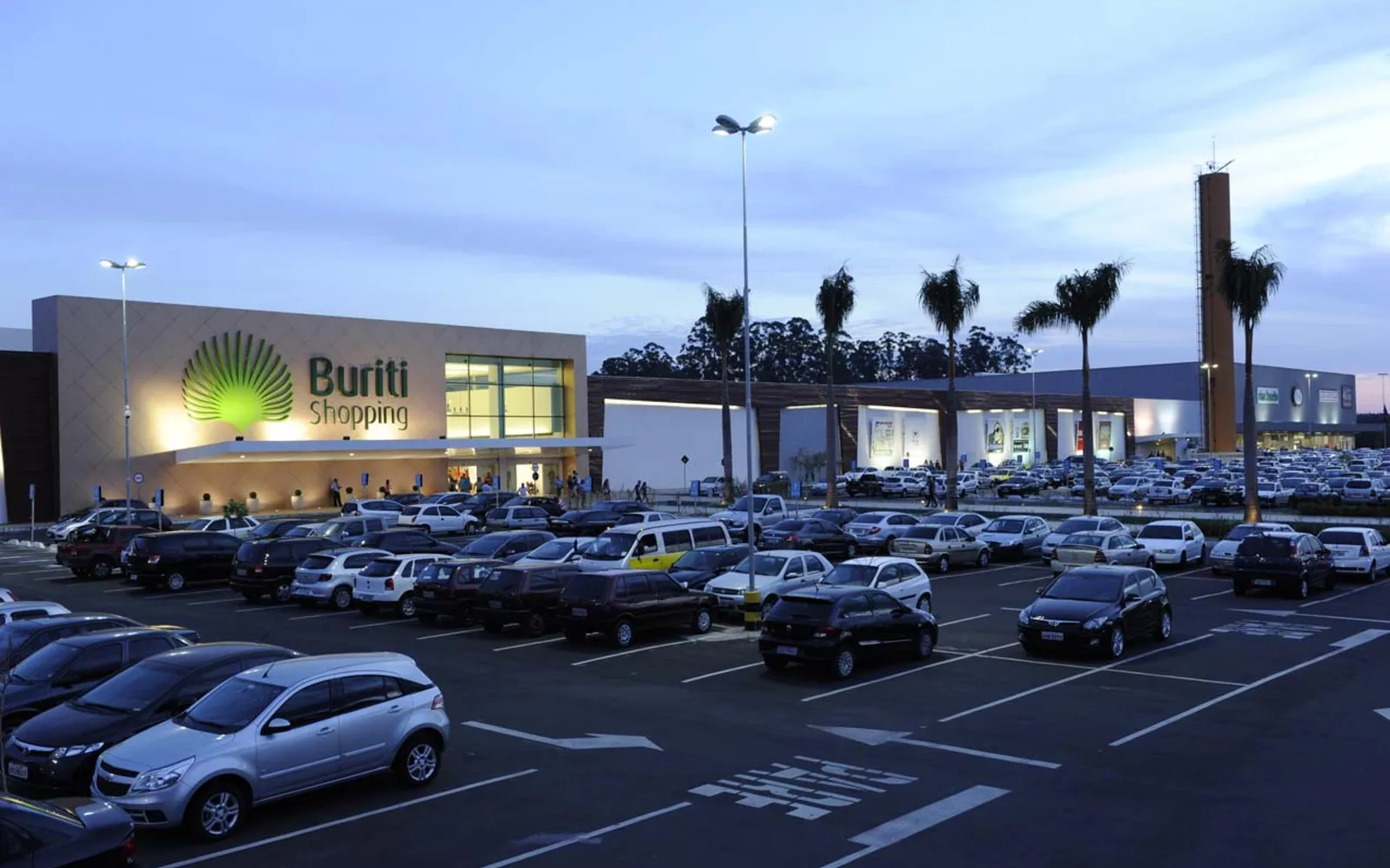 Storefront view of a retail shopping center with multiple shops and commercial signage